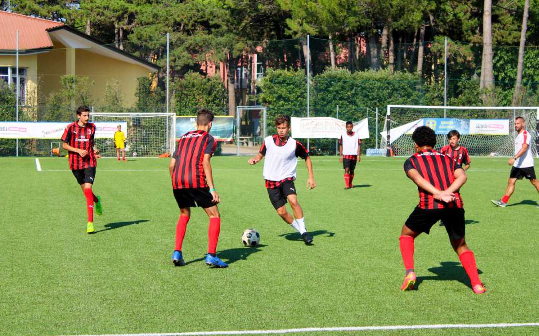 Seven young players during a soccer action in the AC Milan Academy Junior Camp